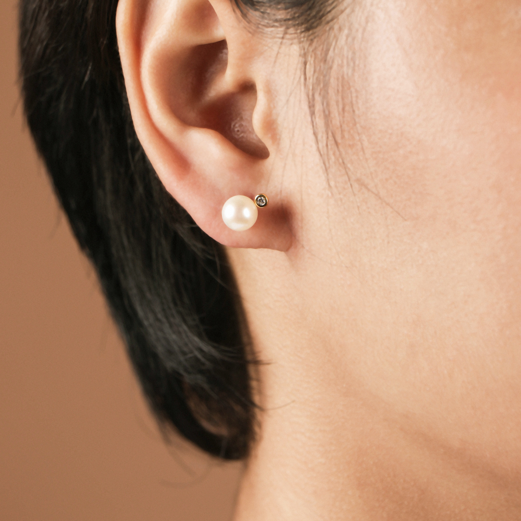 Audrey Pearl Studs 18k gold stacked on model ear – Foundry