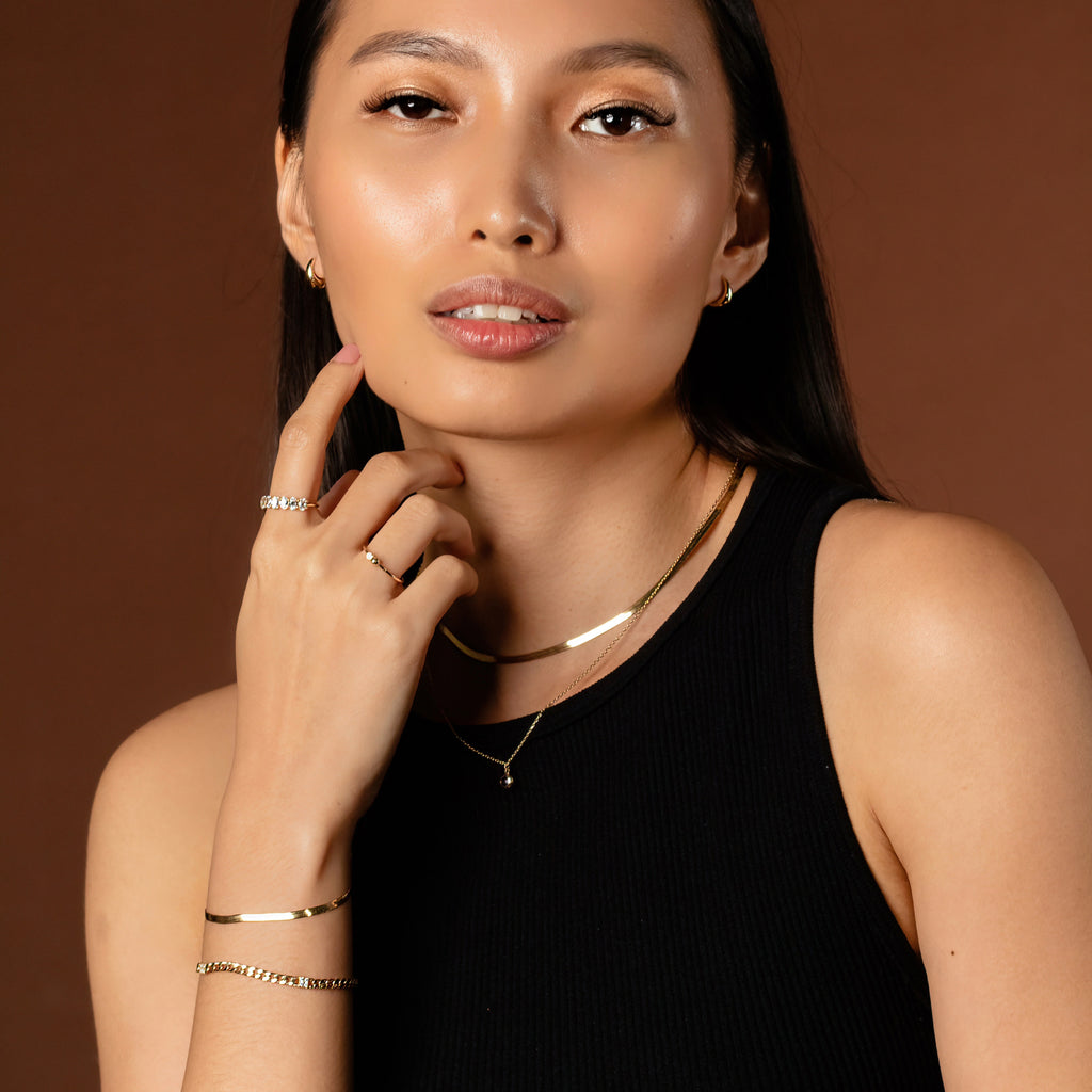 Birthstone Sphere Necklace 14k gold stacked on model neck – Foundry