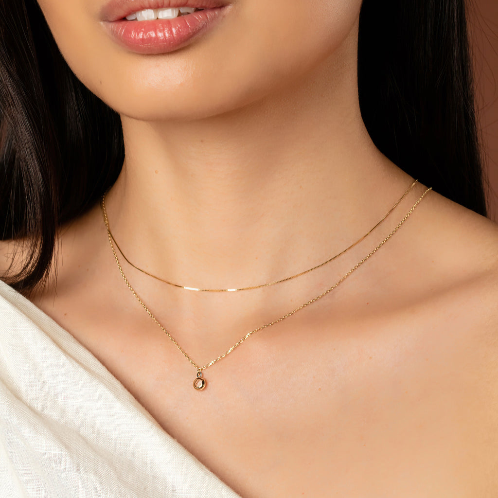 Birthstone Sphere Necklace White Quartz 14k gold stacked on model neck – Foundry