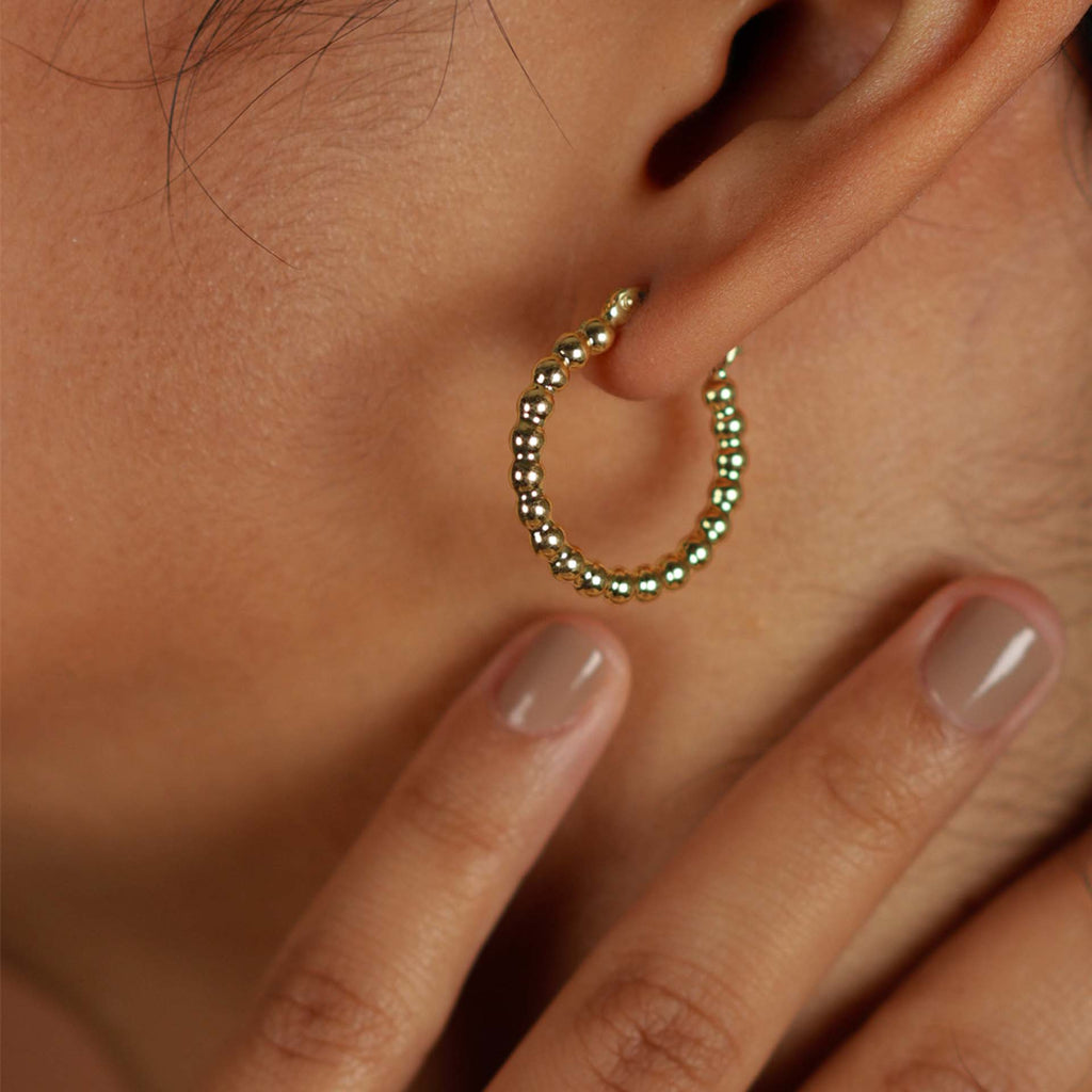 Bold Sphere Hoops 14k gold stacked on model ear – Foundry