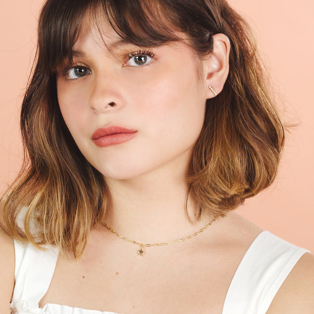 Brilliant Bar Stud 14k gold stacked on model ear – Foundry