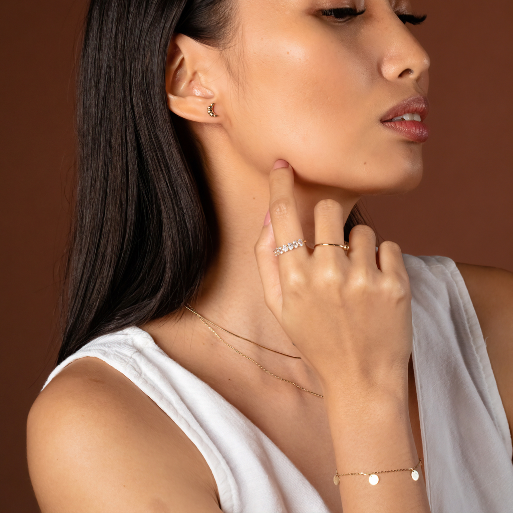 Croissant Studs 14k gold stacked on model ears – Foundry