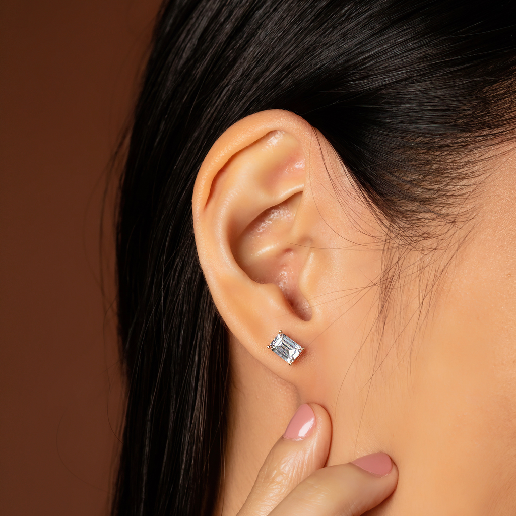 Emerald Cut Studs 14k gold stacked on model ear – Foundry