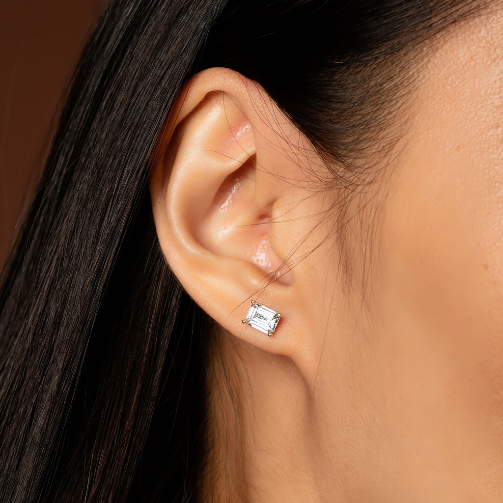 Emerald Cut Studs 14k gold stacked on model ear – Foundry