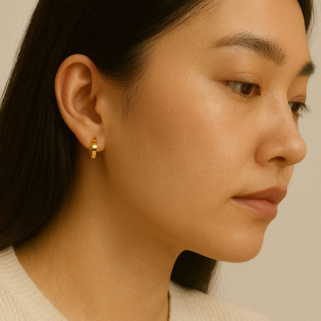 Essential Hoop Earrings 18k gold stacked on model ears – Foundry