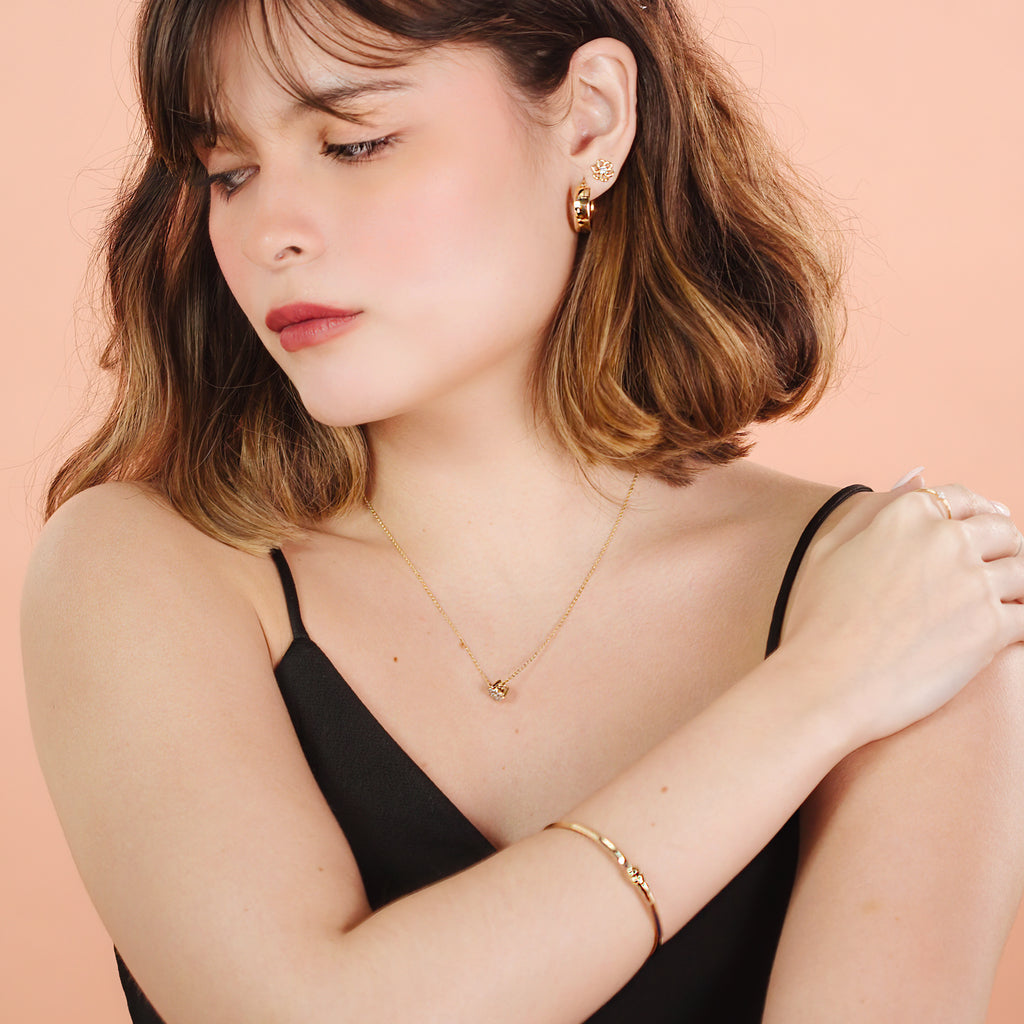 Flower Solo Studs 14k gold stacked on model ear – Foundry