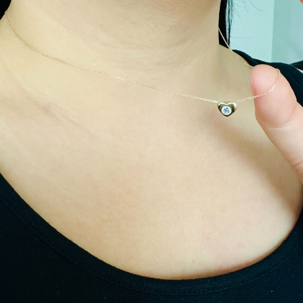 Heart Bezel Necklace 14k gold stacked on model neck – Foundry