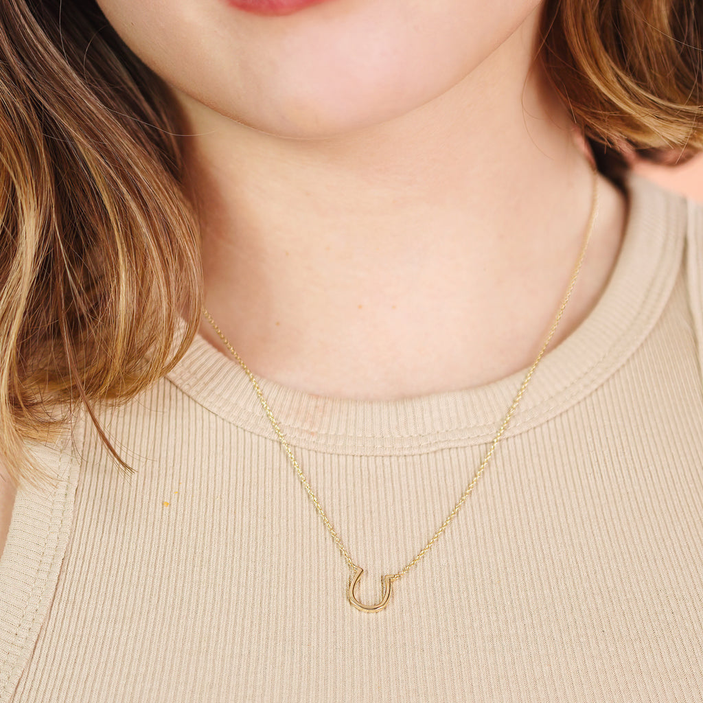 Horseshoe Necklace 14k gold stacked on model neck – Foundry