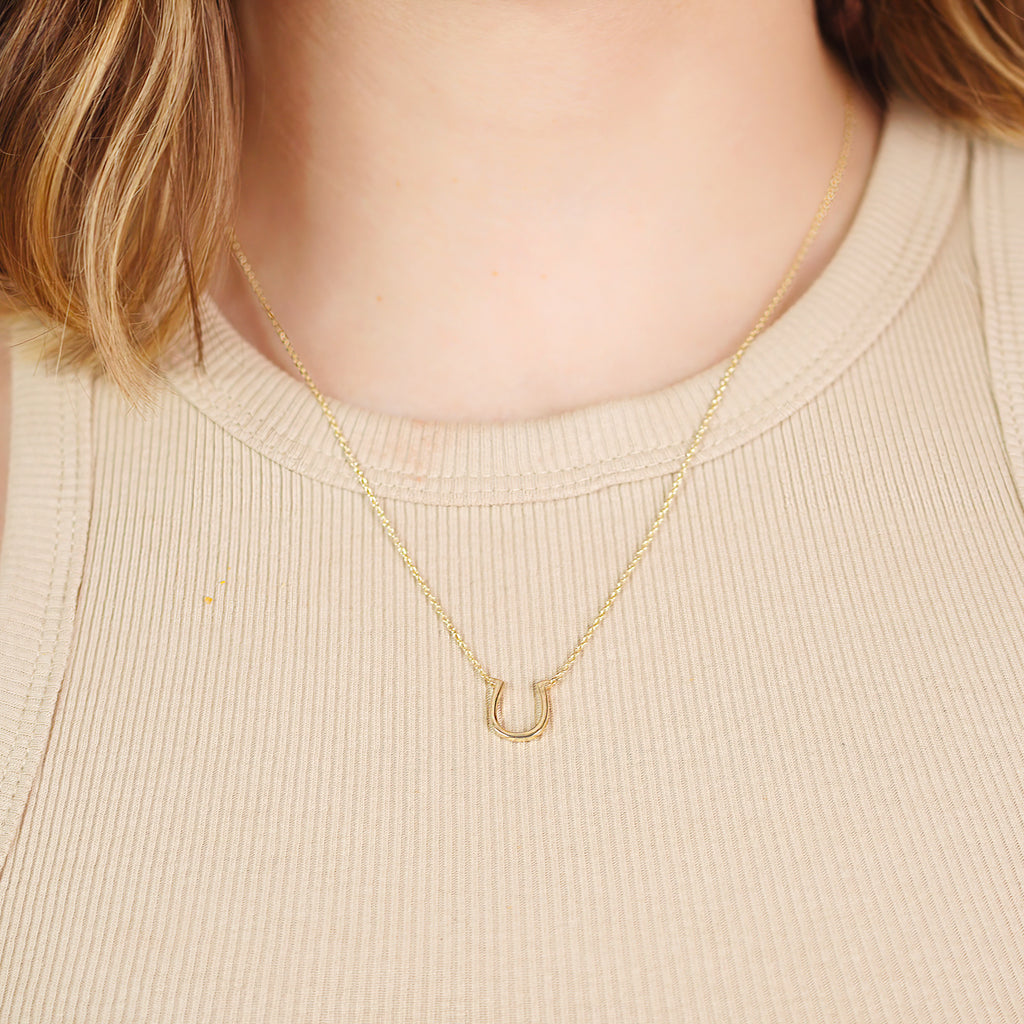 Horseshoe Necklace 14k gold stacked on model neck – Foundry