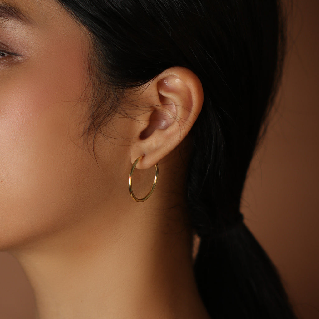 Large easy Hoops 18k gold stacked on model ear  – Foundry