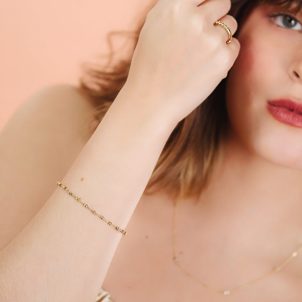 Medium Beads Bracelet 14k gold stacked with bracelet on model wrist – Foundry