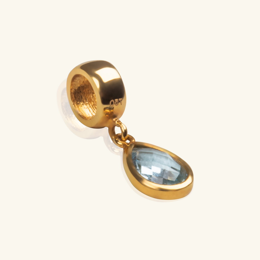Mini Aquamarine Pear Charm 18k gold stacked on model finger – Foundry