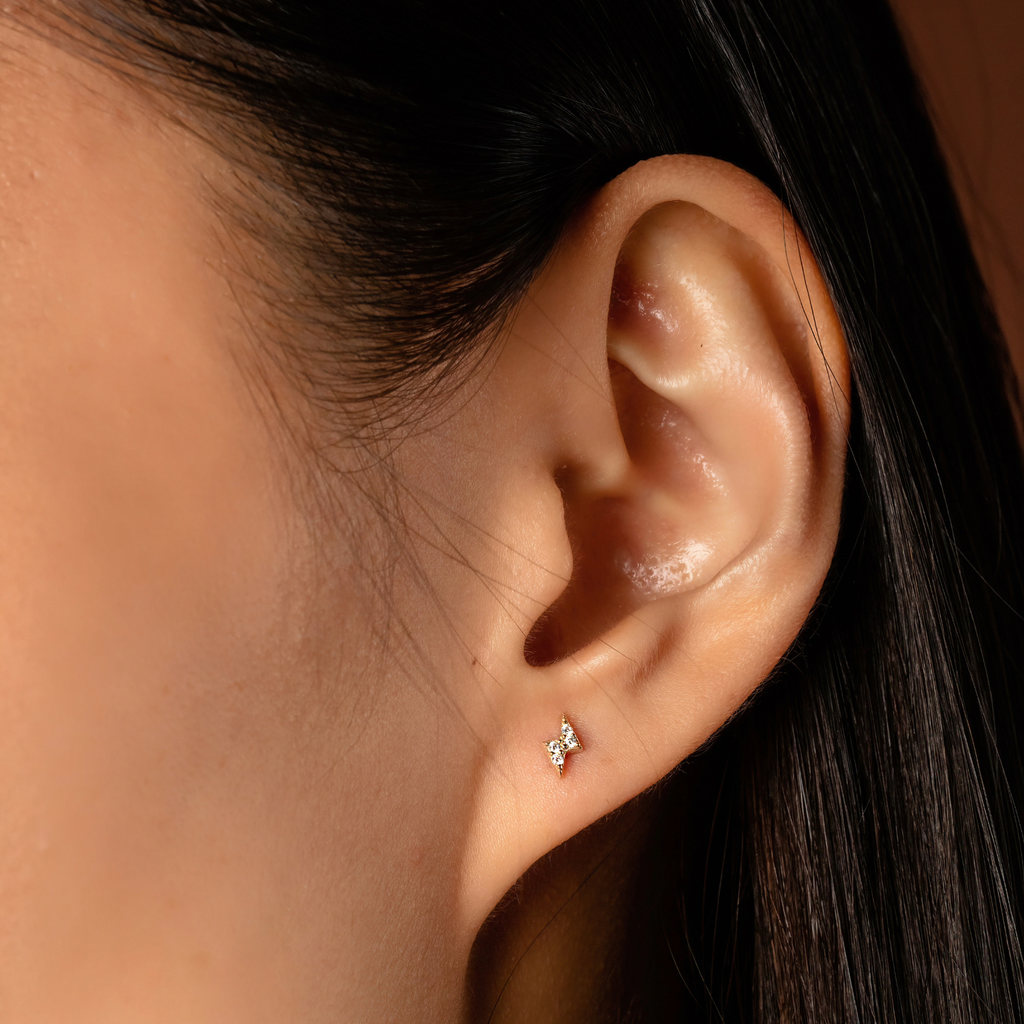 Pave Lighting Bolt Studs 14k gold stacked on model ears – Foundry