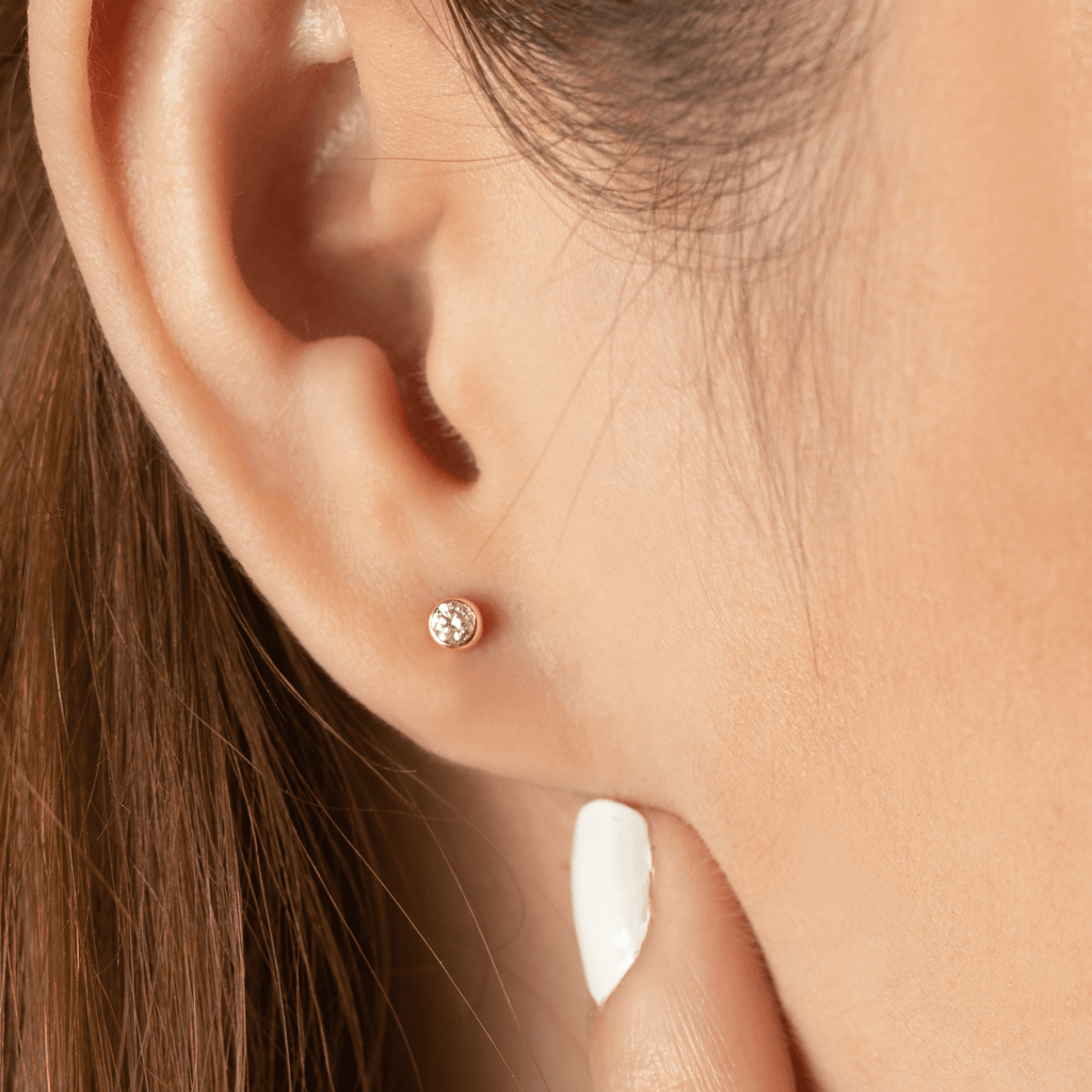 Round Diamond Mini Studs 14k gold stacked on model ears – Foundry