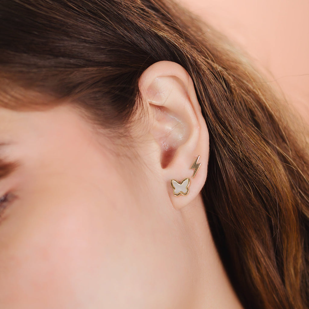 Single Lightning Bolt Stud 14k gold stacked on model ears – Foundry