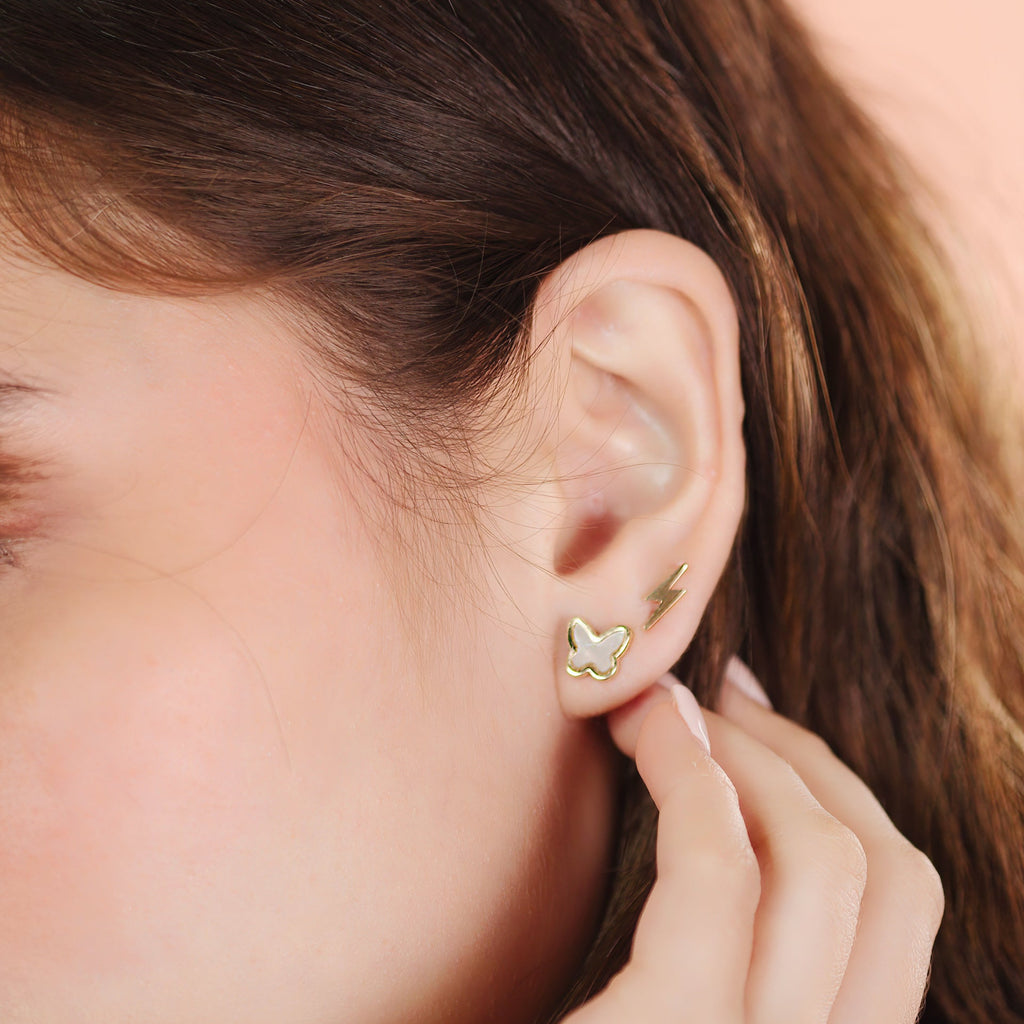 Single Lightning Bolt Stud 14k gold stacked on model ears – Foundry