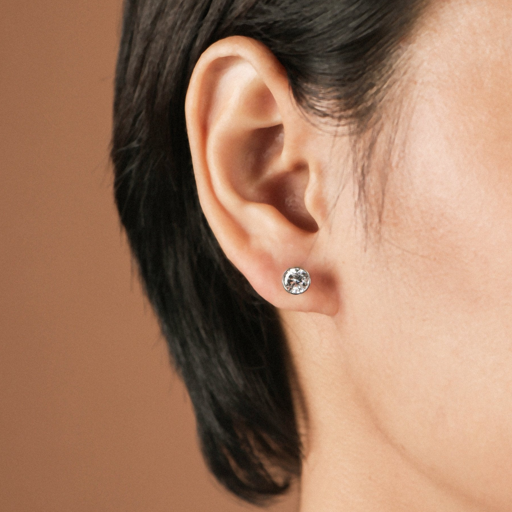 Single Mini Arden Studs 18k white gold stacked on model ear – Foundry