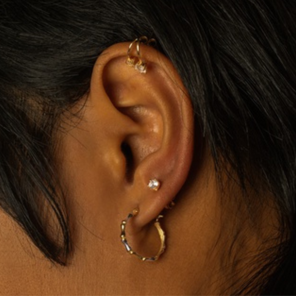 Single Round Mini Stud 18k gold stacked on model ears – Foundry
