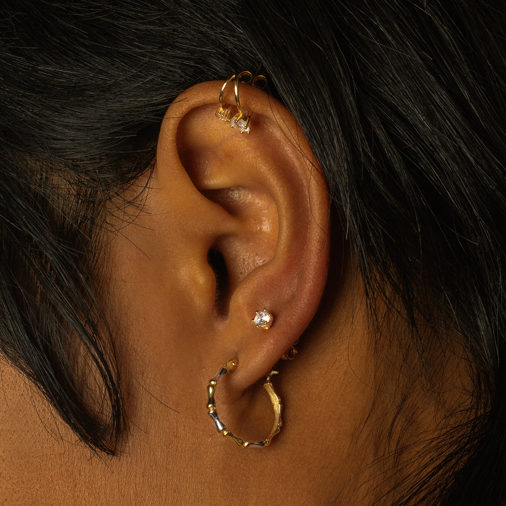 Single Round Mini studs 18k white gold stacked on model ear – Foundry