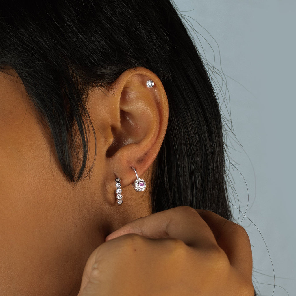 Single Tiny Essential Studs White Gold 18k gold stacked on model ears – Foundry