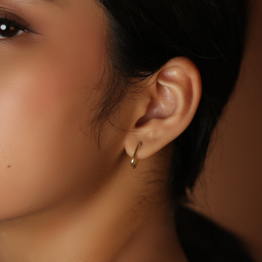 Slim Huggie U Hoops 18k gold stacked on model  ear– Foundry