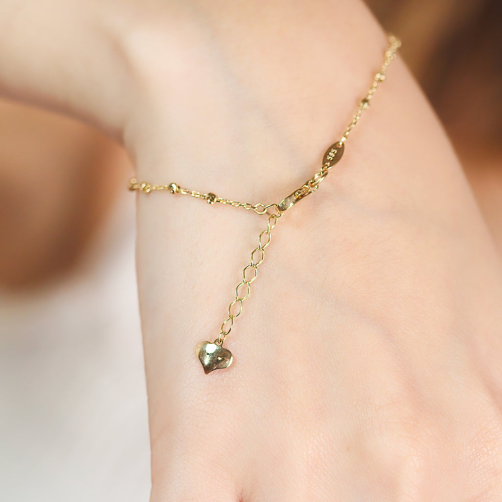 Small Beads Bracelet 14k gold stacked on model wrist – Foundry