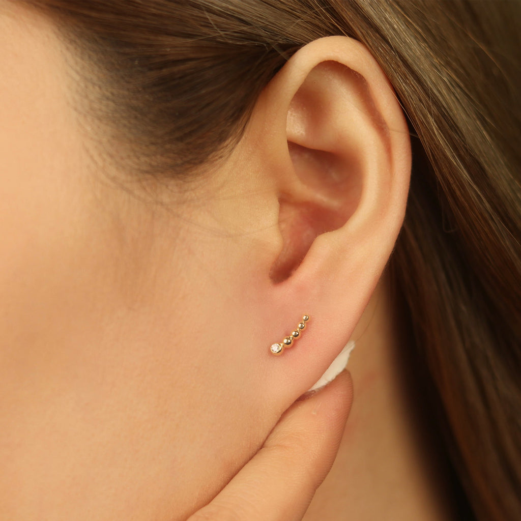 Solo Diamond Spheres Climbers 14k gold stacked on model ear – Foundry