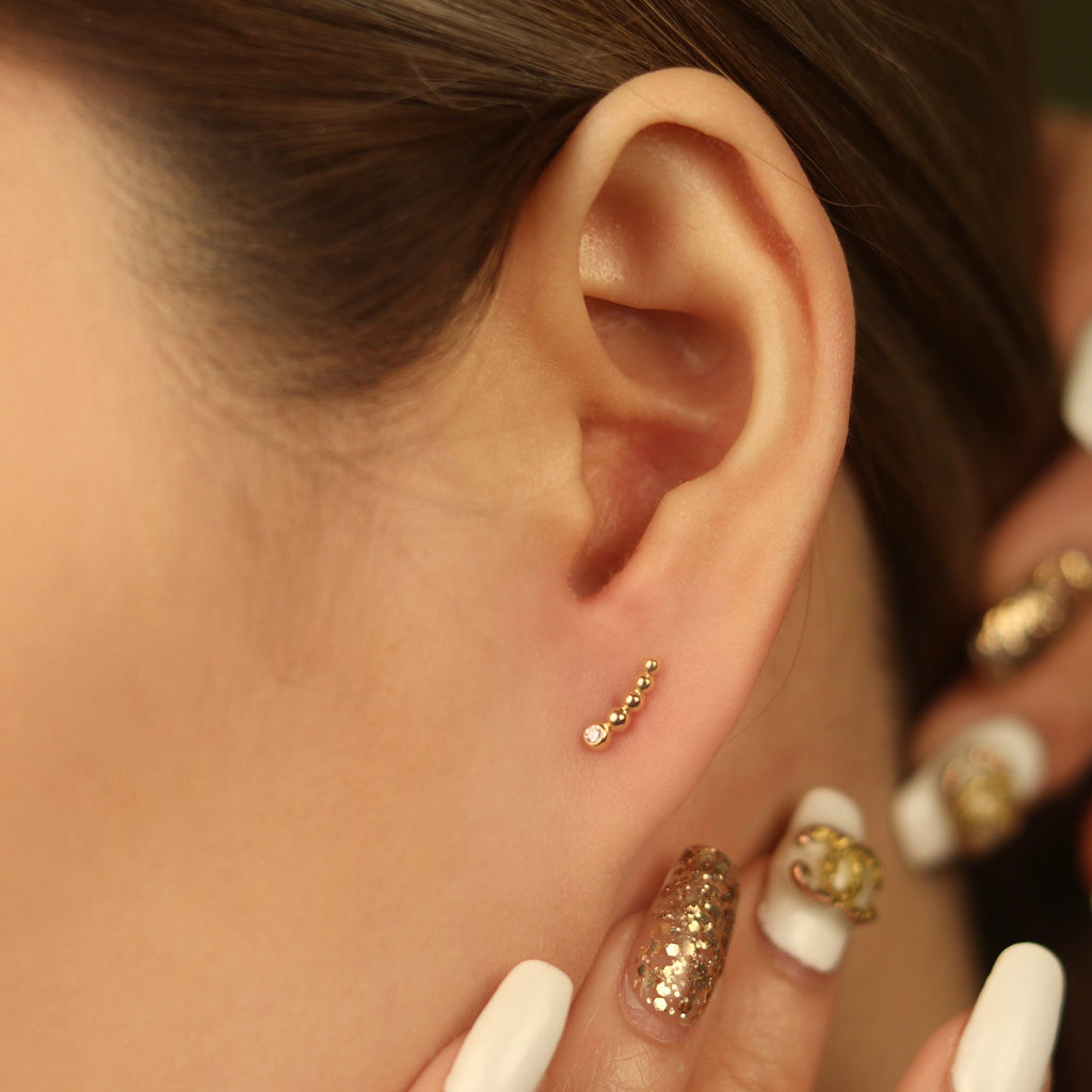 Solo Diamond Spheres Climbers 14k gold stacked on model ear – Foundry