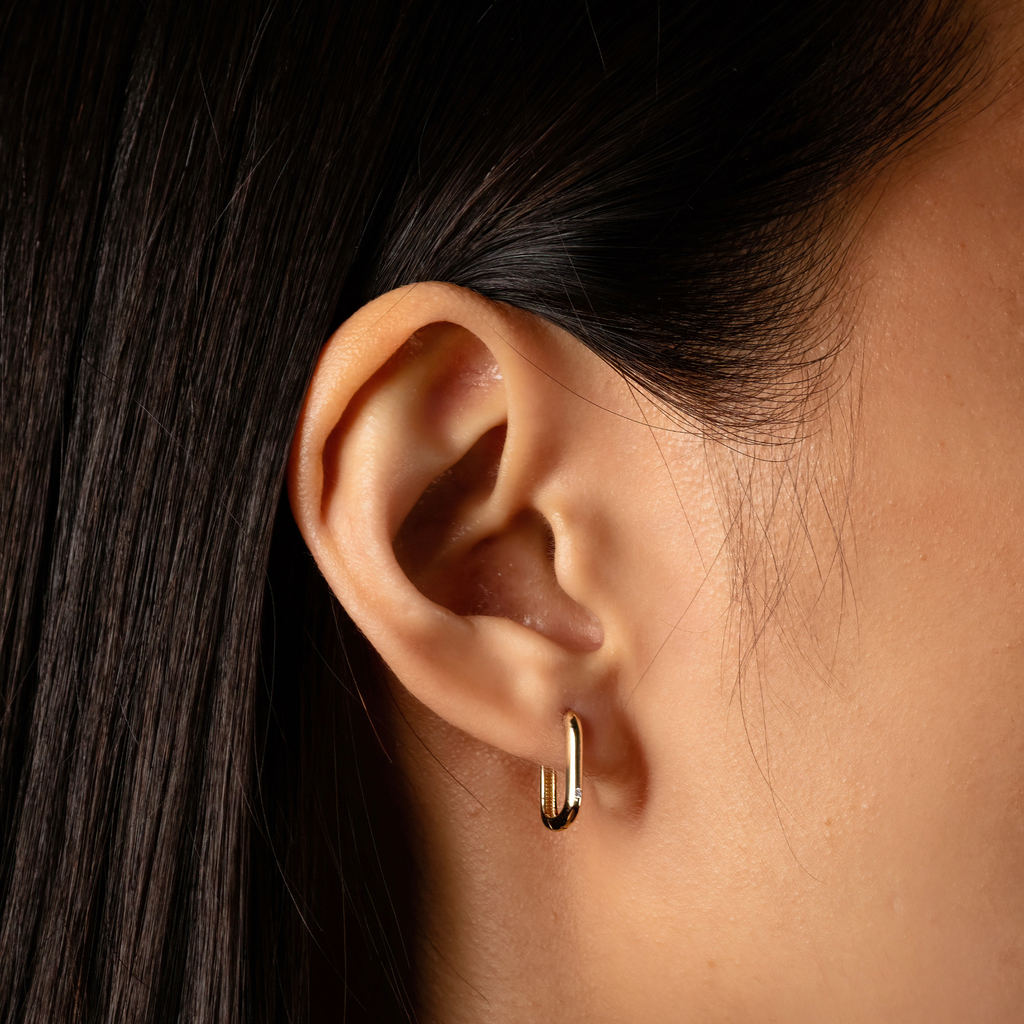 Solo Small U Hoops 14k gold stacked on model ear – Foundry