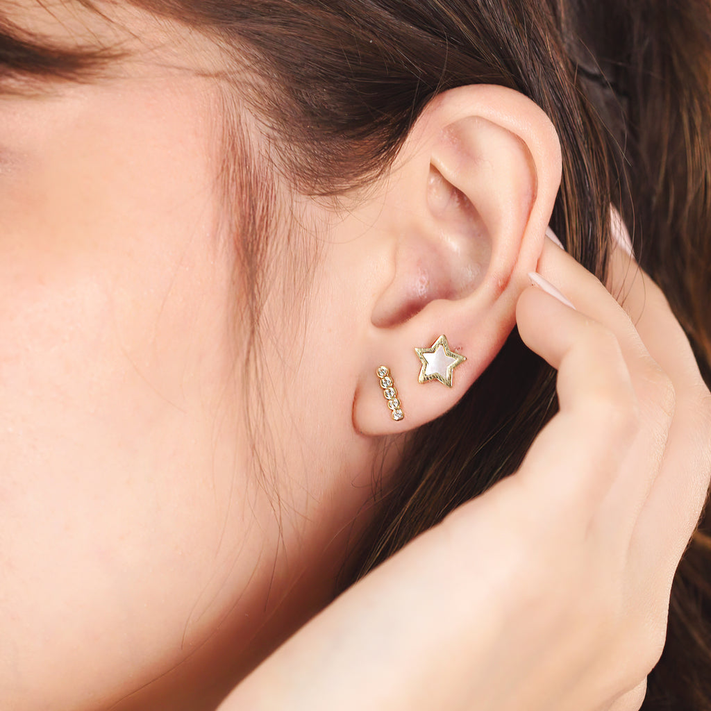 Star Mother of Pearl Studs 14k gold stacked on model ear – Foundry