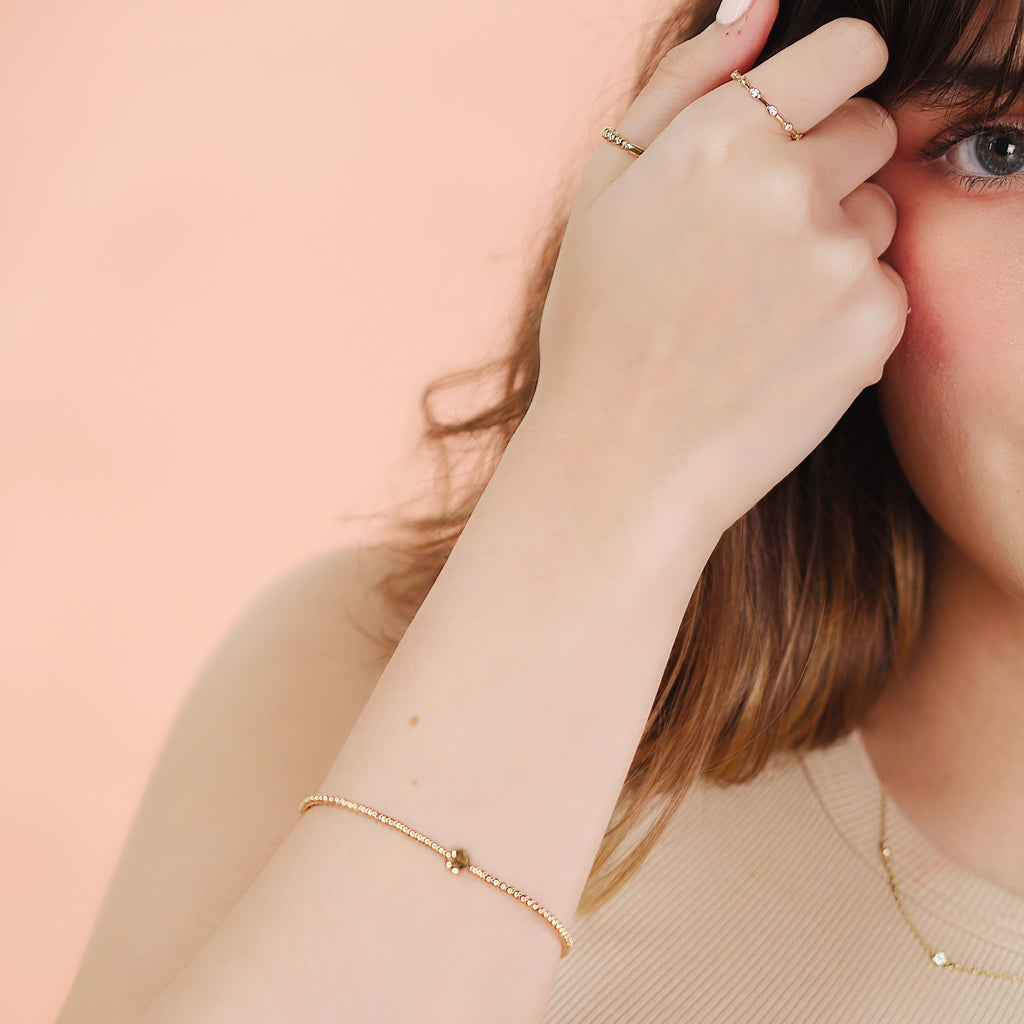 Station Eternity Ring 14k gold stacked on model finger– Foundry