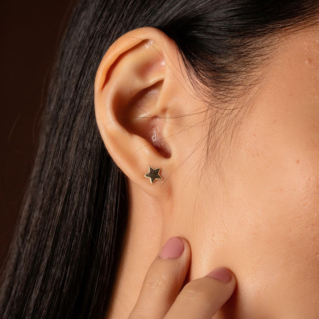 Stellar Studs 14k gold stacked on model ear – Foundry