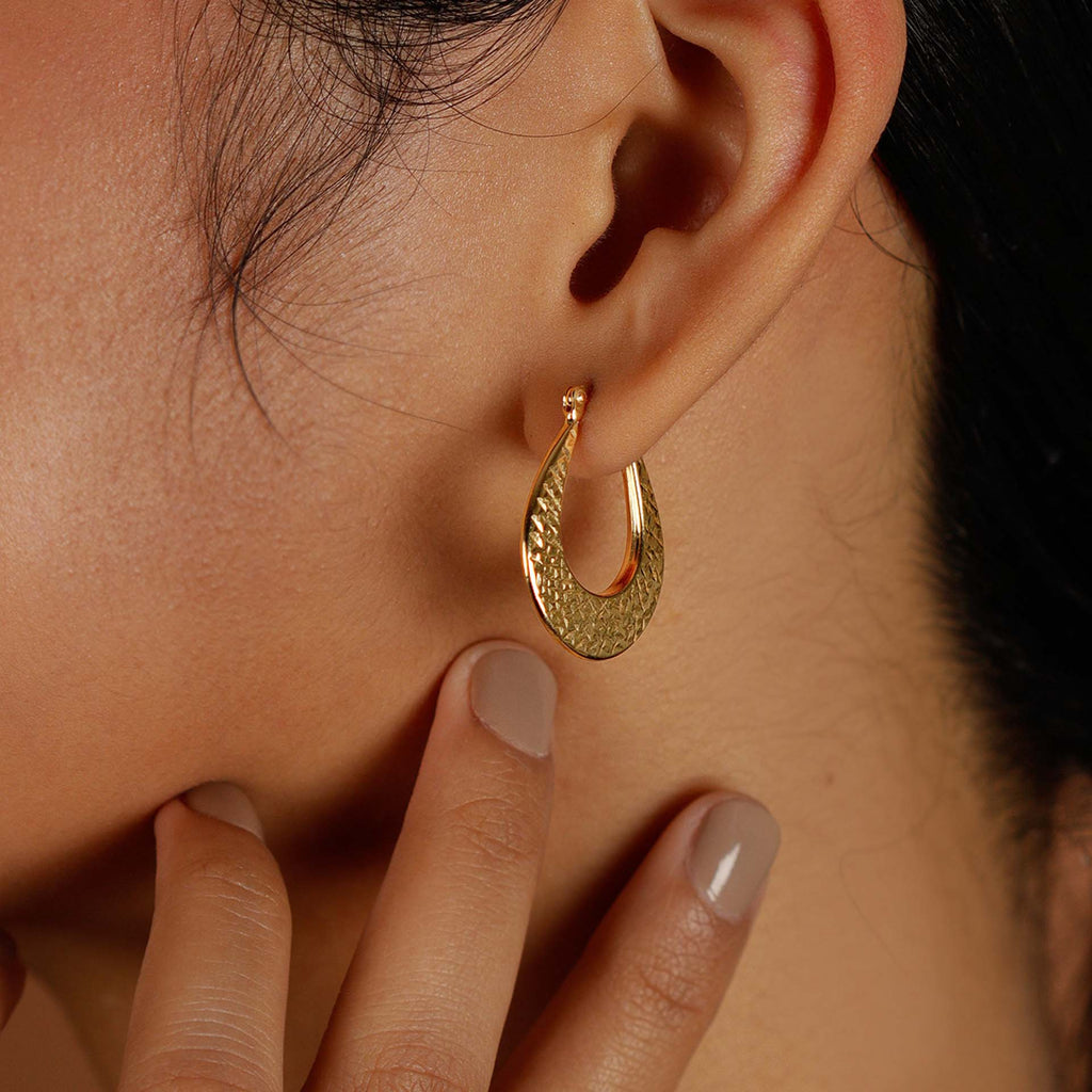 Texture Medium Hoops 18k gold stacked on model ear – Foundry
