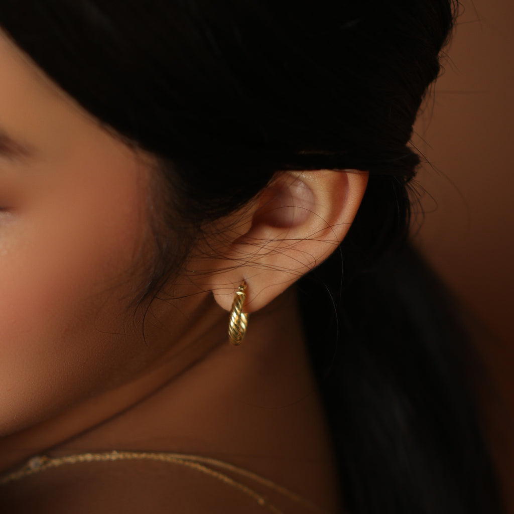 Twirl Hoops 18k gold stacked on model ear – Foundry
