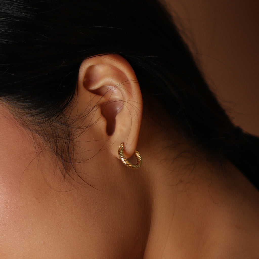 Twirl Hoops 18k gold stacked on model ear – Foundry
