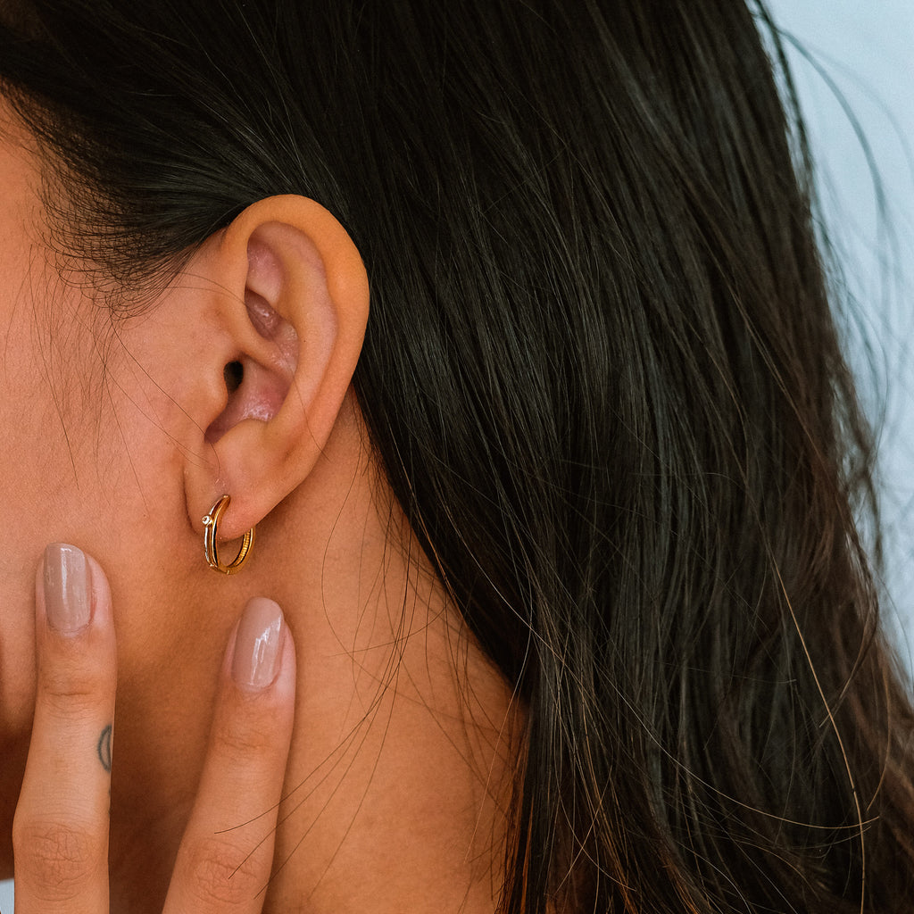 Two Tone Solo Hoops 18k gold stacked on model ear – Foundry